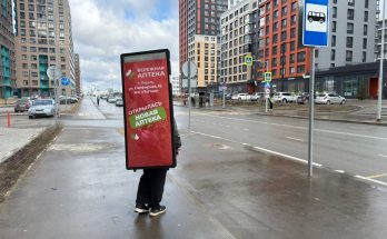 Промоутер с рекламой рюкзаком лайтбоксом за спиной